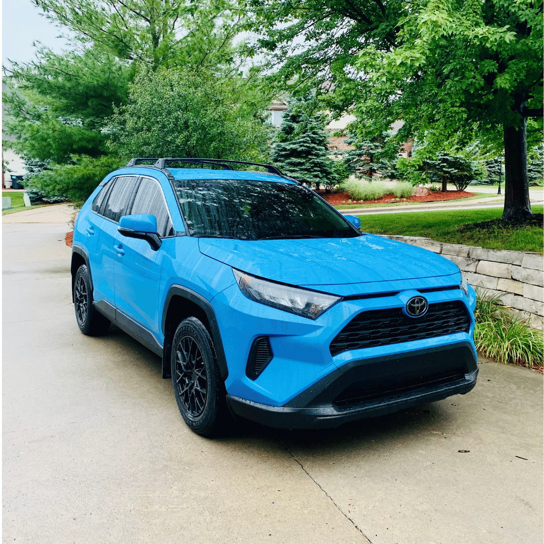 Blue Toyota RAV4 parked in a driveway, clean and glossy exterior